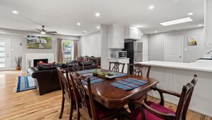 A modern kitchen with white cabinets, a microwave, and a refrigerator. - Spacious 5BR Near Bishop Arts - 5 Min Drive! (Dallas)