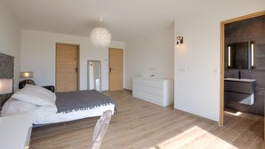 Une chambre à coucher moderne avec un lit, une commode et un miroir.