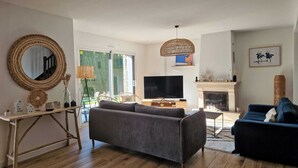 A modern living room with a grey sofa, a television, and a fireplace.