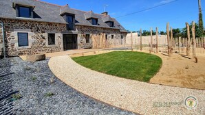 A stone house with a sloped roof, a paved driveway, and a grassy lawn. - Des deux plages - PLERIN (PLERIN)