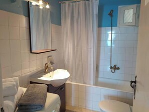 A bathroom with a sink, mirror, towel, shower, and toilet. - Als Plomari - Sea View Apartment (Plomari)