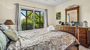 A bedroom with a large bed, a dresser, a ceiling fan, and a view of greenery through a sliding door. - The Overlook /Hot Tub/Mountain Views/Babbling Creek/Fire Table (Maggie Valley)