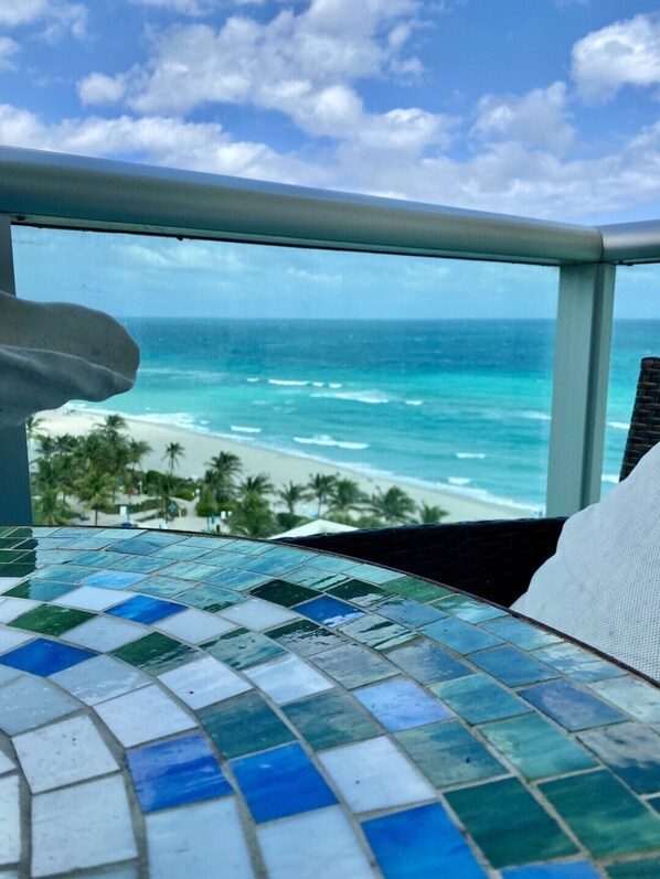Ein Balkon mit Blick auf den Ozean und den Strand.