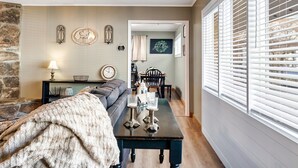 A cozy living room with a sofa, a coffee table, and a dining area with a table and chairs.