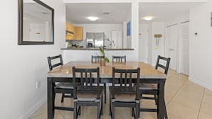 A dining area with a marble table and dark wooden chairs, a kitchen with stainless steel appliances in the background, and a white door labeled "Master Bedroom". - Cozy 3BR/2BA  King Bed  Free Parking  Pet-Friendly (Miami)