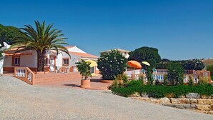 A coastal property with a paved driveway, palm trees, and a building with a tiled roof. - Villa Mariposa, Lagos beach, private pool (Lagos)