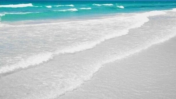 Una playa de arena blanca y agua turquesa.