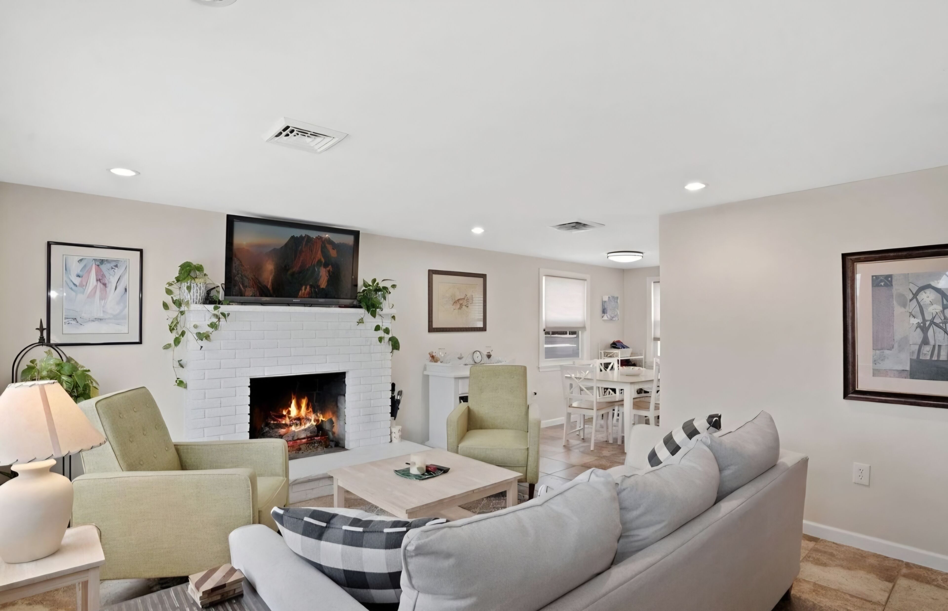 A living room with a fireplace, a sofa, a coffee table, and a TV.
