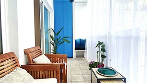 A sunlit balcony with wooden chairs, a small table with a plate, and a potted plant. - Abbott apartment - 100m2 - 3 bedrooms, living room, 2 terraces, 1 min to beach (Sitges)