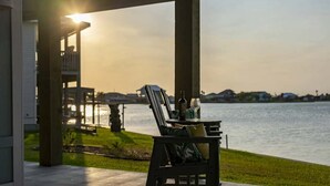 A patio with a table set for two, overlooking a body of water. - Luxury Lake Retreat w/ Pool, Spa, Kayaks & Views! (Rockport)
