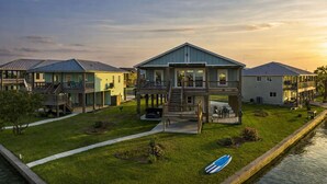A waterfront residential area with houses featuring balconies and a central house with a covered deck. - Luxury Lake Retreat w/ Pool, Spa, Kayaks & Views! (Rockport)