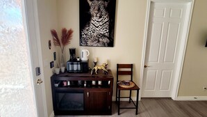 Eine Küchenzeile mit Mikrowelle, Kaffeemaschine und Dekoration auf einem Holzkorpus.