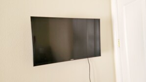 Ein Flachbildfernseher an einer schlichten Wand.