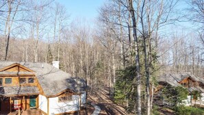 Une cabane avec une façade en bois, un porche couvert et un chemin de terre menant à l’entrée.