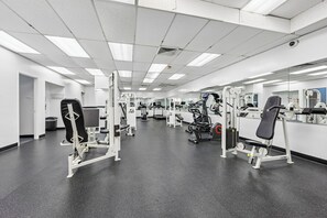 A gym with various exercise equipment, a black rubber floor, and white walls. - Luxury Duplex Apartment - Free Garage parking close to DC (Alexandria)