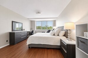 Ein modernes Schlafzimmer mit einem großen Bett, einem Schreibtisch und einer Kommode.