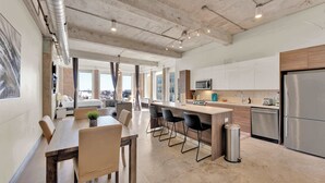 A modern kitchen with a central island, stainless steel appliances, and a view to the outside. - Spacious Downtown Loft | Free Breakfast & Pool (Dallas)