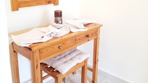 A wooden vanity with a mirror, a candle, and a bench. - Corfu Escape Three (Corfu)
