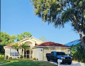 A single-story house with a brown roof, a garage, and a driveway. - Pool, pool table, 4 bedroom, 2.5 bath home with very high rating! (Brandon)