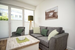 A modern living room with a grey sofa, a wooden coffee table, and a floor lamp.