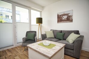 Un salon moderne avec un canapé gris, une table basse en bois et un lampadaire.