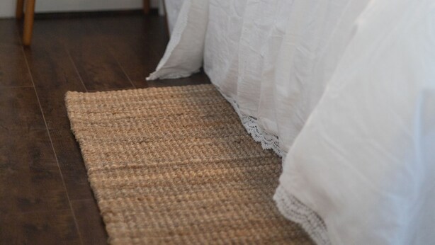 Une chambre à coucher avec un lit, une table de chevet avec une lampe et une carte accrochée au mur.