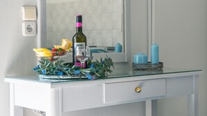 A bathroom vanity with a mirror, a television mounted above it, and a bottle of wine on the counter. - Rodi blue (Malevizi)