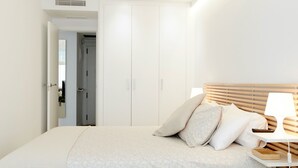 A bedroom with a bed, bedside table, lamp, and wardrobe. - Beautiful Loft Area Santiago Bernabeu Madrid (Madrid)