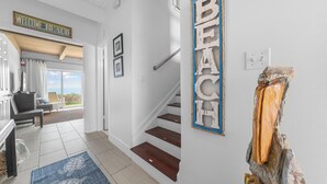 A staircase leading to a balcony with a 'Welcome to Beach' sign, a wooden floor, and a 'Beach' sign on the wall. - Peaceful Beachfront Oasis-- Walk onto the sand! (Melbourne Beach)