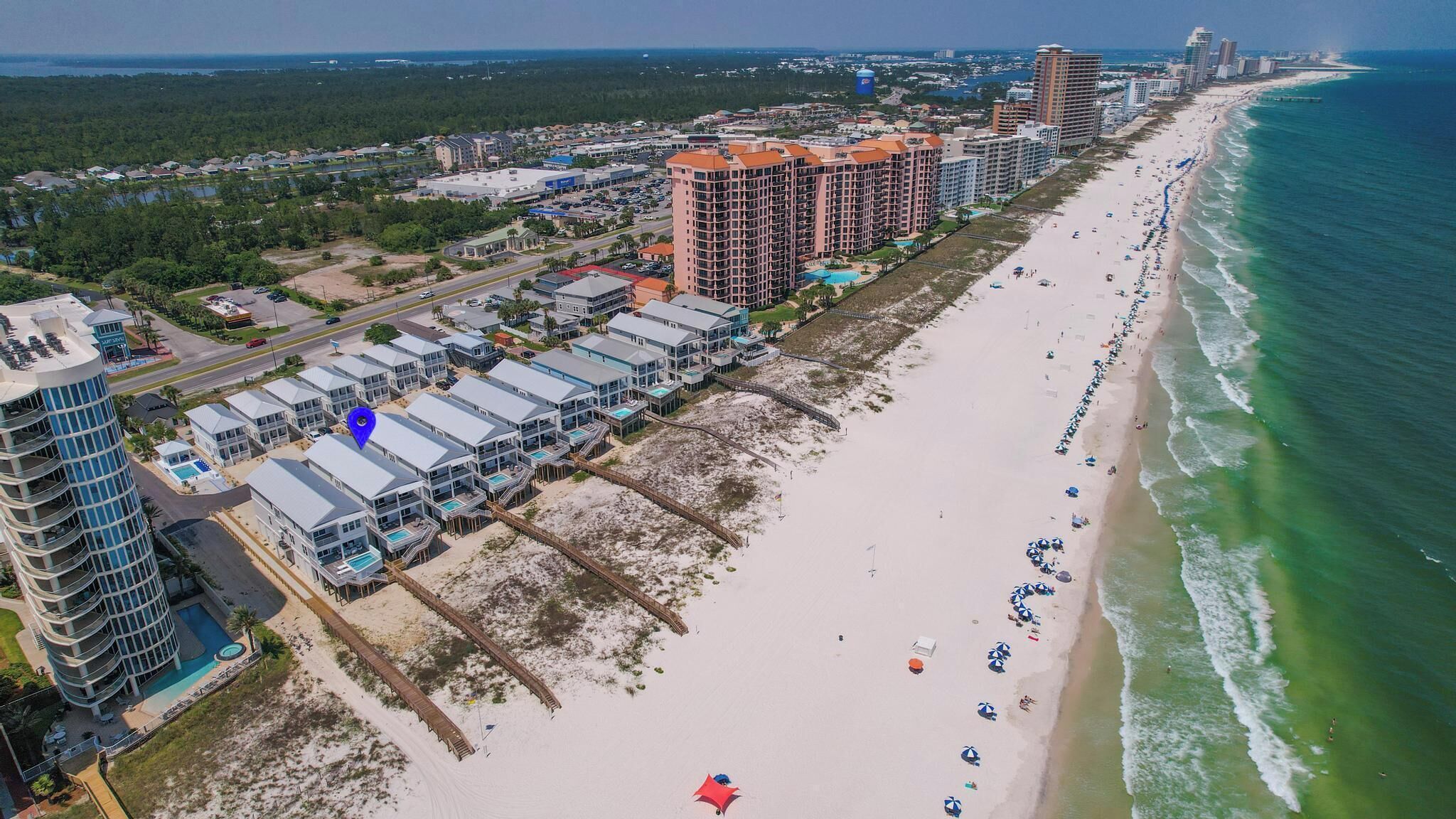 Un hôtel situé sur la côte, composé de plusieurs bâtiments, avec une plage et une vue sur l’océan.