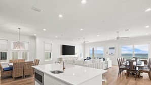 A spacious living area with a large island, a dining table, and a view of the ocean. - Ocean Edge 9 | Beach Front, Plunge Pool, Boardwalk | Paradise Found by Kaiser (Orange Beach)