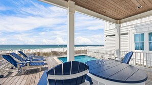 A covered outdoor area with a pool, lounge chairs, and a table. - Ocean Edge 9 | Beach Front, Plunge Pool, Boardwalk | Paradise Found by Kaiser (Orange Beach)