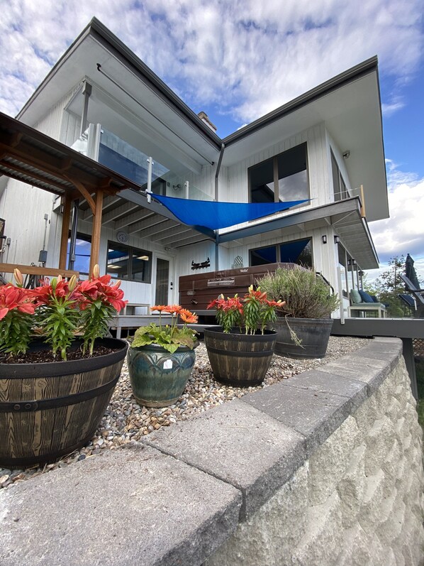 Une maison moderne à deux étages dotée d’un grand patio.