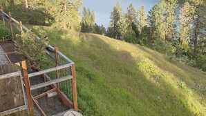 Una terraza de madera con vistas a un lago y una ladera boscosa al fondo.
