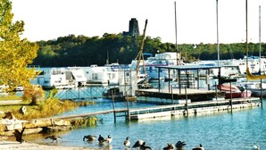 Un puerto deportivo con barcos amarrados, un muelle y un pequeño edificio.