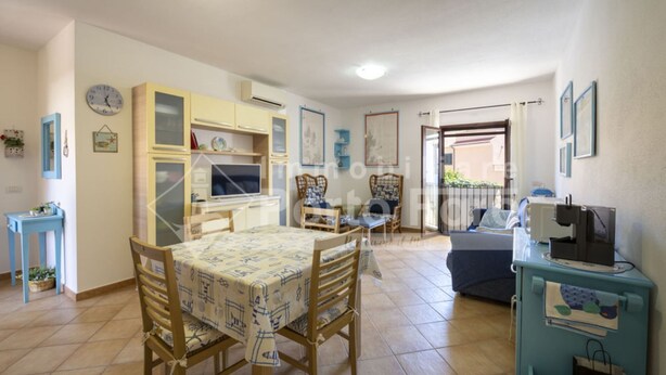 Una sala de estar acogedora con una mesa de comedor, sillas, un sofá y un televisor.