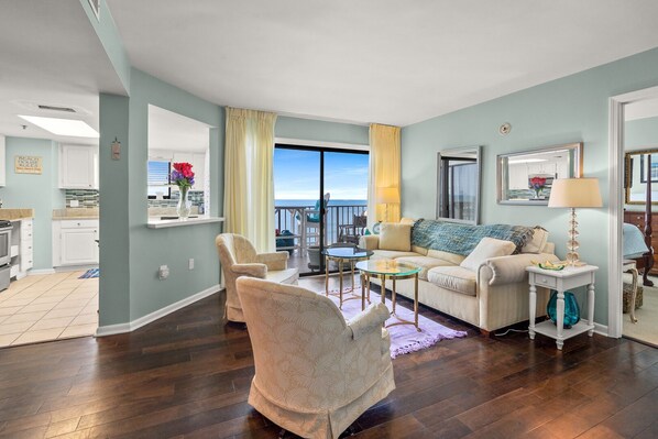 A living room with a sofa, armchairs, a coffee table, and a view of the ocean. - Superb oceanfront condo w/pool, sundeck, private balcony near pier for fishing, walking, crabbing (North Myrtle Beach)