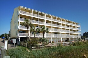 Ein mehrgeschossiges Hotel mit Balkonen in Strandnähe.