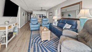 A modern living room with a sofa, two armchairs, a coffee table, and a TV. - Fantastic, budget-friendly option for your next beach vacation (North Myrtle Beach)
