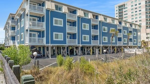 A multi-story hotel with balconies, a parking area, and a beach view. - Your Classic Oceanfront Retreat in North Myrtle Beach! (North Myrtle Beach)