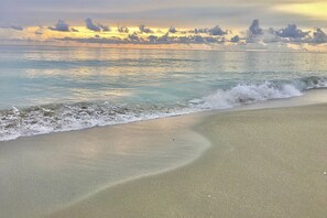 Ein Strand mit sanften Wellen und blauem Himmel.