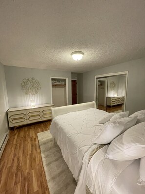 Cozy retreat with a comfortable bed, dresser, and mirror.