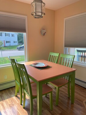 Enjoy meals in this cozy dining area with a table and four chairs, featuring a window with a view of the surrounding neighborhood.