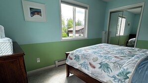 A bedroom with a bed, a dresser, a window, and a mirror. - 3 Bedroom-Queen Beds-UMed-Stunning Mountain Views-Trails to lakes (Anchorage)