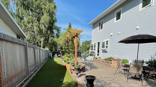 A backyard with artificial turf, a wooden pergola, a patio with outdoor furniture, and a house in the background. - 3 Bedroom-Queen Beds-UMed-Stunning Mountain Views-Trails to lakes (Anchorage)