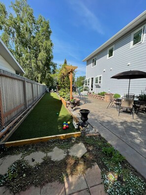 Enjoy a serene outdoor retreat with a patio, fire pit, and lush greenery.