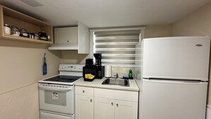 A compact kitchen with a stove, microwave, and refrigerator.