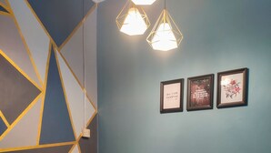 Une salle de conférence dotée de murs au décor géométrique, d’une table en bois, de quatre chaises et de trois citations inspirantes encadrées.