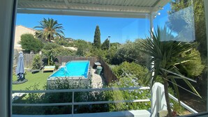Zona exterior coberta amb una piscina, envoltada de vegetació i vistes a una vessant de muntanya.