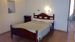 A single bed with a wooden frame and a headboard with a light fixture. There is a small bedside table to the left of the bed. - Country house near Cabreret (Orniac)